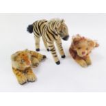 Three stuffed toy animals, possibly Steiff, comprising a zebra, recumbent lion and a recumbent leopa