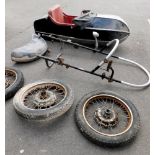 A motorcycle sidecar, together with three wheels, two for the bike, one for the sidecar, and a mudgu