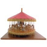 A vintage mid century steam driven carousel, with three concentric rows of horses, some with riders,