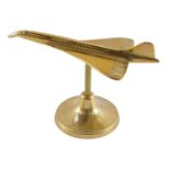 An aeronautical brass desk stand, modelled as Concorde 18.58, 18.5cm wide.