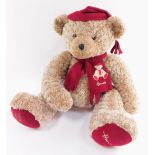 A large Harrods Teddy Bear, seated, wearing a red scarf and cap, 49cm high.