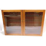 A mahogany two door collector's cabinet, with four glass shelves, 65cm high, 95cm wide, 16.5cm deep.