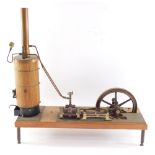 A scratch built wheel driven steam boiler, in wood and metal, raised on a wooden base, 55cm wide.