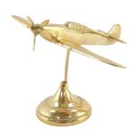 A brass aeronautical desk stand, modelled as a Hurricane fighter plane, 19cm wide.