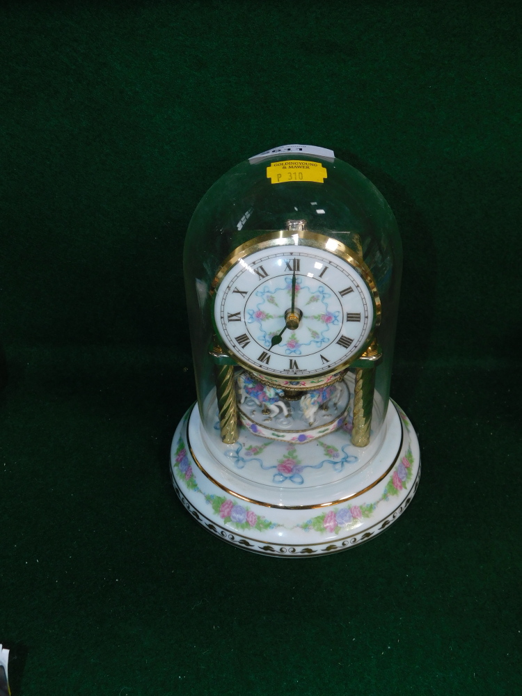 A ceramic anniversary clock, with painted dial above carousel, 20cm high.