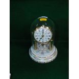 A ceramic anniversary clock, with painted dial above carousel, 20cm high.