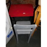 A child's wooden desk, painted red and black, together with a chair painted grey. (2)