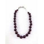 A modern pearl effect graduated necklace, with a maroon type lustre finish, with chrome heart clasp,