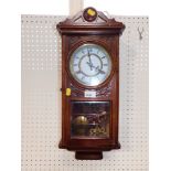 An oak cased wall clock.