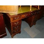 A reproduction mahogany pedestal desk, with green tooled leather insert.