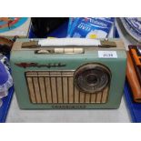 A Rhapsody Deluxe Transiter portable vintage radio, in green case.