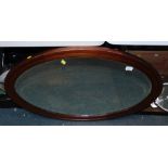 An Edwardian oval mahogany inlaid wall mirror.