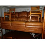 A tan leather three seater sofa.