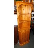 A pine corner cabinet.