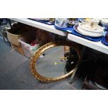 A gilt framed circular wall mirror.