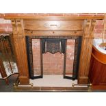 An oak fire surround, with cast iron inset, lacking tiles, with marble base, and brass fender. (4)