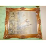 An oil on canvas by Redmond of pheasants in flight, gilt framed.