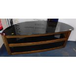 A black glass television stand with wood effect base.
