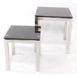 A pair of graduated brushed metal and smoked glass occasional tables, each of plain form, 56cm high,