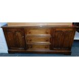 An oak veneered sideboard, of three drawers flanked by linenfold cupboard doors.