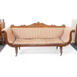 A Regency flame mahogany scrolling sofa, with a foliate carved back, blue and white patterned fabric
