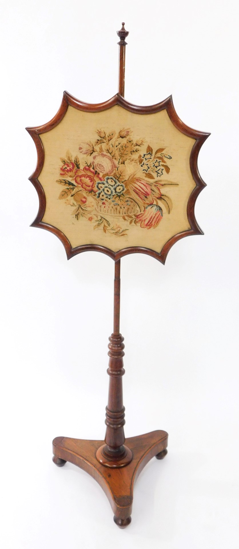 An early Victorian rosewood fire screen, the shaped screen with wool work floral tapestry, raised on