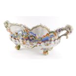 A French late 19thC faience pottery jardiniere, of twin handled lobed form, moulded with scrolls and