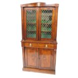 A Regency Egyptian Revival rosewood cupboard bookcase, the triangular shaped pediment set centrally