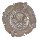 An Art Nouveau late 19thC pewter circular dish, pierced and embossed with a bust portrait of a lady,