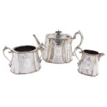 A Victorian silver plated three piece tea set, with foliate scrolled engraving, oval reserve, monogr