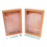 A pair of pale mahogany wall mounted display cabinets, each with a glazed door including three narr