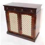A Regency mahogany side cabinet, with two frieze drawers above a pair of doors with grilled and fabr