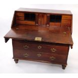 A George III mahogany bureau, the fall flap opening to reveal a central door, flanked by semi secret