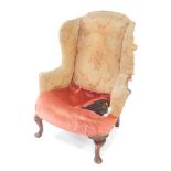 A George II mahogany framed wingback armchair, for re-upholstery, raised on cabriole legs.