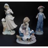 Three Lladro porcelain figures, comprising a kneeling girl with doll and ironing board, standing gir