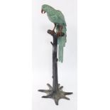 A cast painted metal figure of a parrot, modeled on a perch, 125cm high.