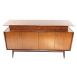 A GPlan 1950's teak sideboard, designed by E Gomme, with three recessed drawers above a pair of leve