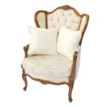 A French 16thC style pale beech wingback fauteuil, upholstered in pale gold floral button back