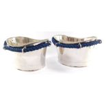 A pair of stainless steel ice baths, each cast with six rings, united by blue woven rope, 24cm high,