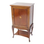 An Edwardian mahogany and inlaid side cabinet, with a single panelled door opening to reveal two she