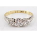 A three stone diamond ring, each round brilliant cut diamond set in raised illusion platinum setting