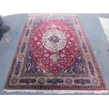 An Isfahan rug, with red and blue ground, decorated with a central floral medallion within interlace