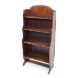 A Victorian oak waterfall bookcase, of four shelves, raised on shaped end supports, 26cm high.