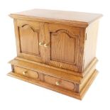 An oak jewellery chest, the out swept pediment over a pair of doors inset internally with mirrors, o