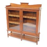 A Victorian oak glazed bookcase, with a shaped gallery over a pair of glazed doors enclosing