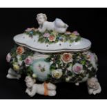 A Sitzendorf early 20thC porcelain casket and cover, of quatre lobed form, encrusted with roses, and