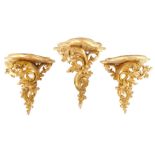 A pair of rococo style gilt wood wall shelves, of serpentine form, raised on fillet scroll supports,