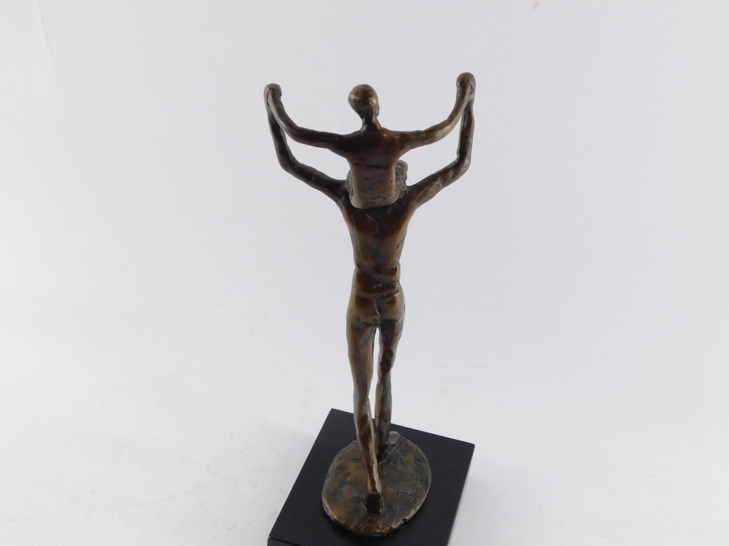 A bronze figure of a father modelled standing with a child on his shoulders, bears signature, raised - Bild 4 aus 5
