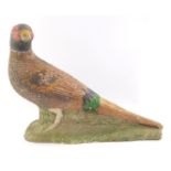 A stone figure of a cock pheasant, modelled on a naturalistic ground, 44cm wide. (AF)