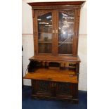 A Victorian oak secretaire bookcase, the out swept pediment over a pair of glass fronted doors, with